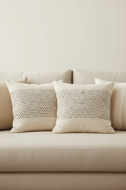 Misty kussenhoes in naturelkleur met zwartkleurig geweven patroon 50 × 50 cm, in een verzorgde woonsetting met zichtbare textuur en vorm.