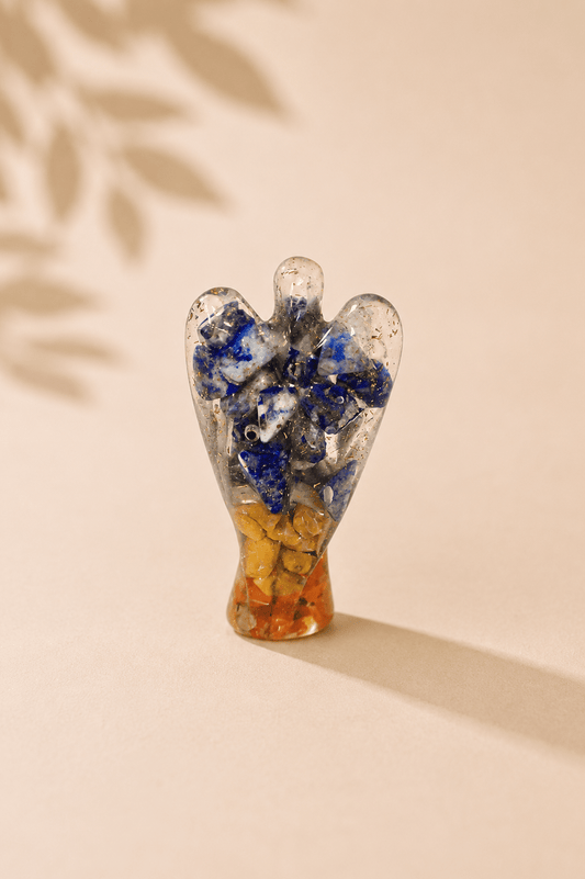 Orgoniet engel 50 mm met edelsteenchips en koper op een beige gebladerde achtergrond