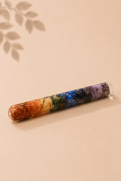 Orgoniet healing wand met chakra-edelstenen en koper op een gebladerde beige achtergrond