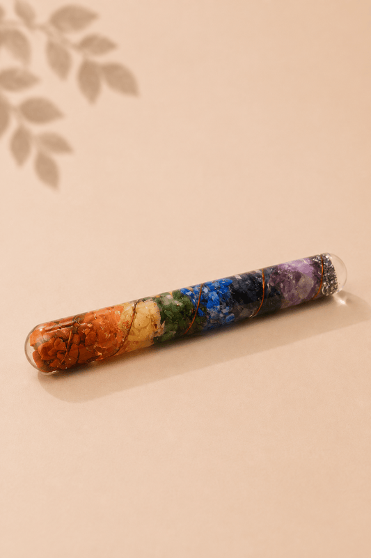 Orgoniet healing wand met chakra-edelstenen en koper op een gebladerde beige achtergrond