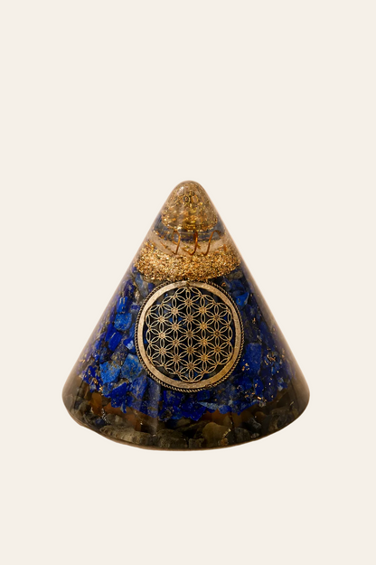 Orgoniet kegel met lapis lazuli, bergkristal en Flower of Life op een lichte beige achtergrond als productfoto