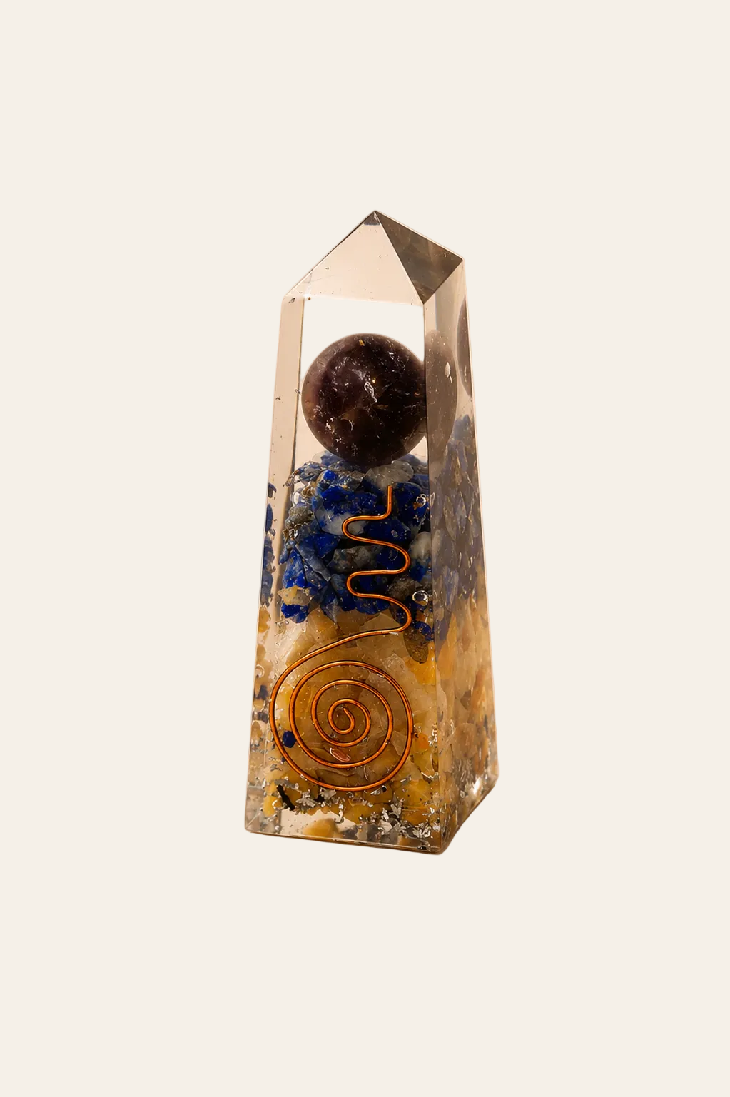 Orgoniet obelisk met lapis lazuli en gele aventurijn op een licht beige achtergrond als productfoto