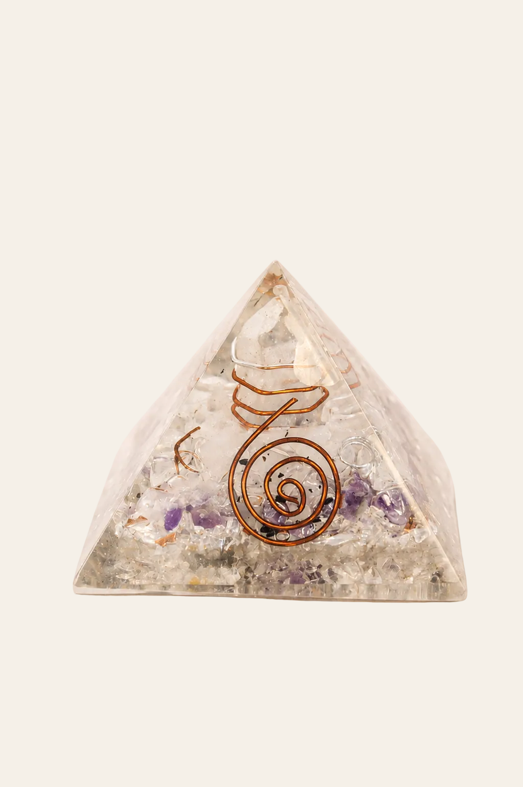Orgoniet piramide 55 mm met edelsteenchips en koper op een lichte beige achtergrond
