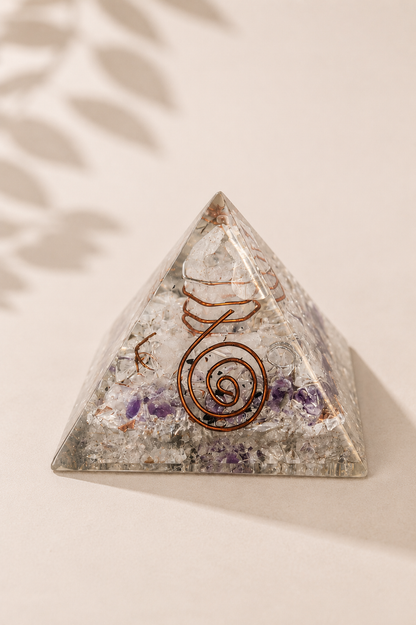 Orgoniet piramide 55 mm met edelsteenchips en koper op een licht beige gebladerde achtergrond
