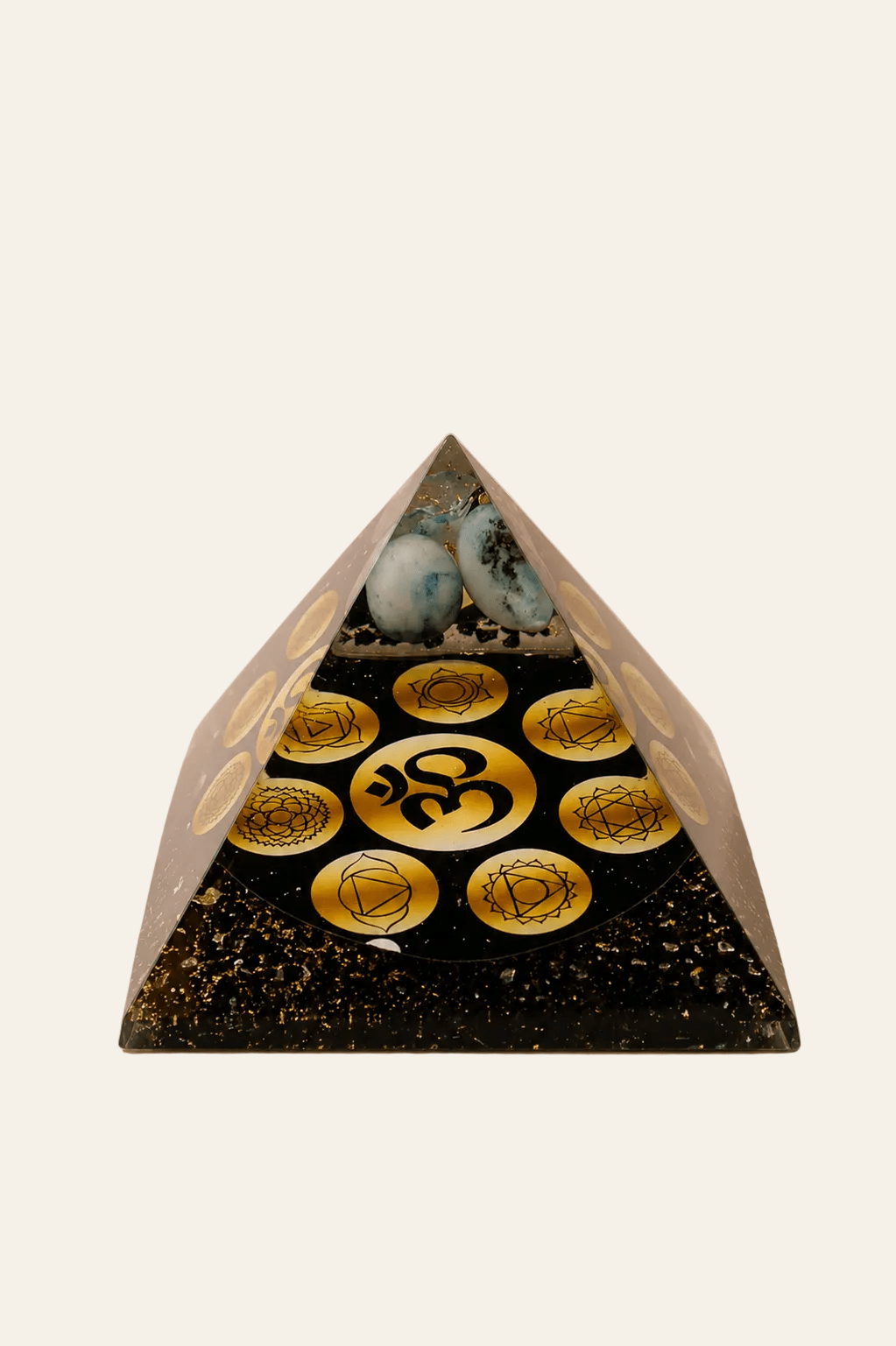 Orgoniet piramide Midnight OM Chakra op een licht beige achtergrond als een productfoto