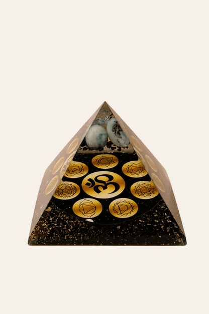 Orgoniet piramide Midnight OM Chakra op een licht beige achtergrond als een productfoto