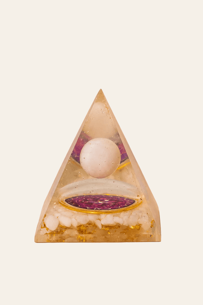 Orgoniet piramide met zwevende bergkristal bol op een lichte beige achtergrond als productfoto