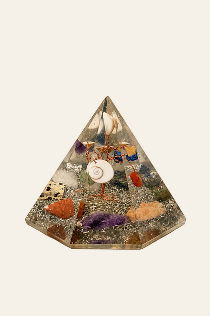 Orgoniet zevenhoekige piramide met levensboom op een licht beige achtergrond als productfoto