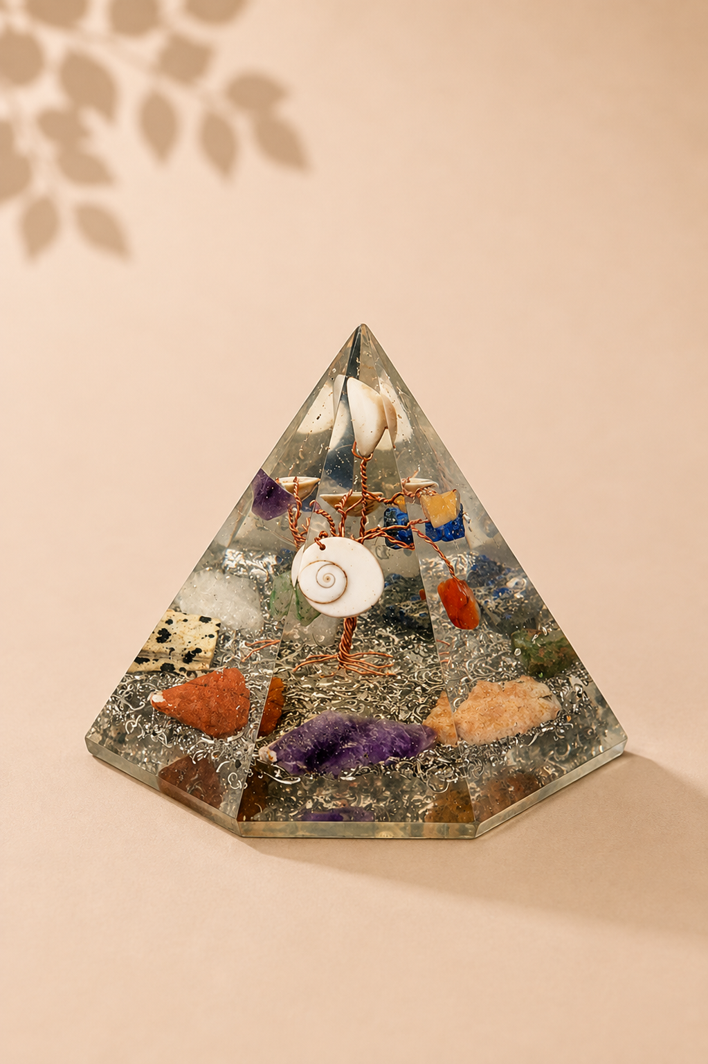 Orgoniet zevenhoekige piramide met levensboom op een beige gebladerde achtergrond