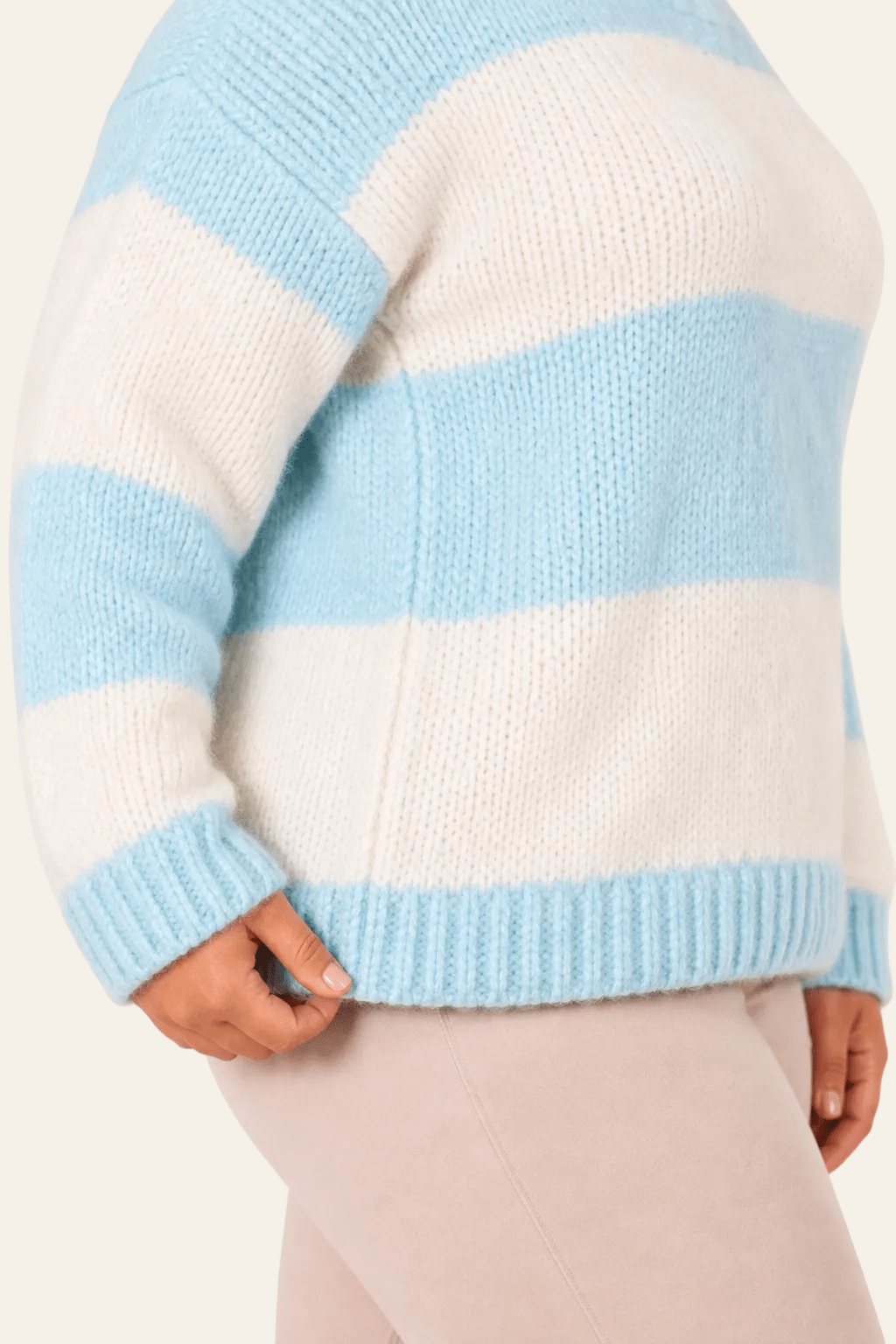 Detail van snit, naad en zoom van oversized damestrui met streeppatroon.