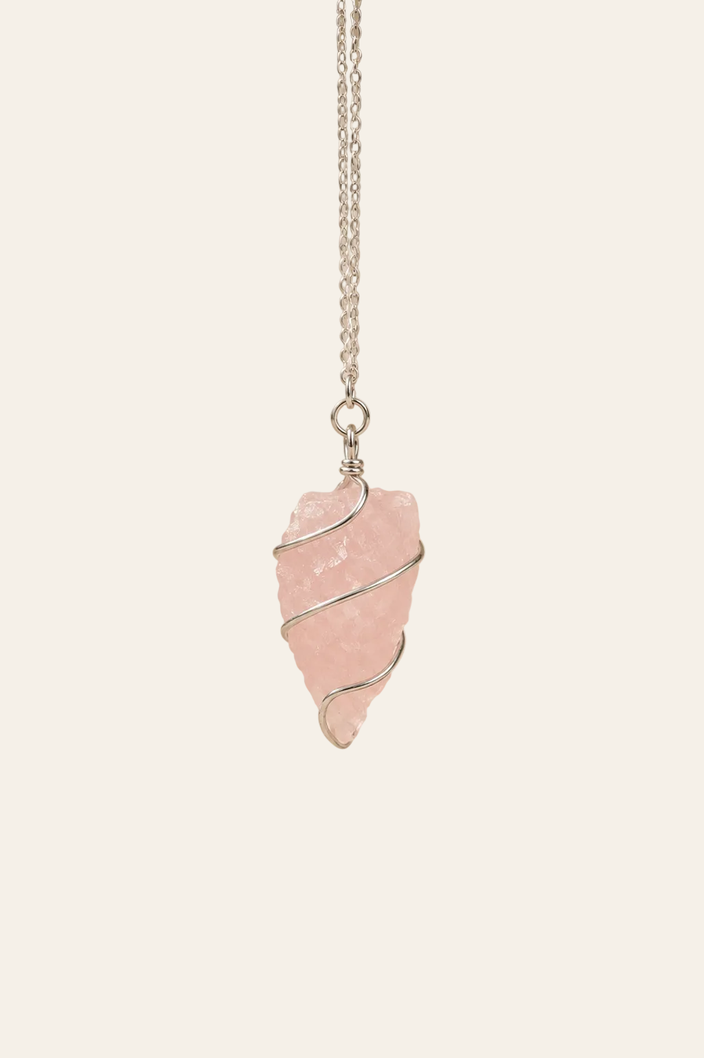 Pendel van ruwe rozenkwarts op een licht beige achtergrond als productfoto