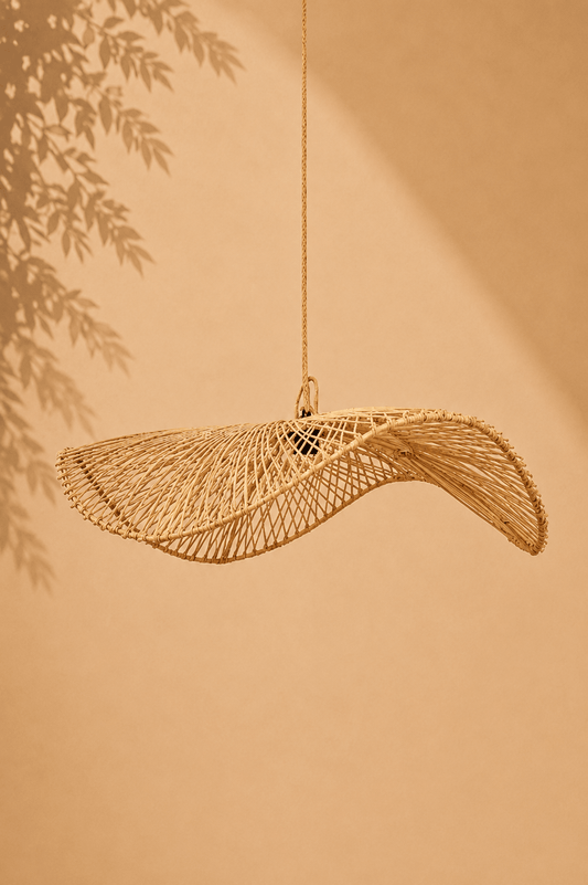 Rotan hanglamp in organische golfvorm op een beige gebladerde achtergrond
