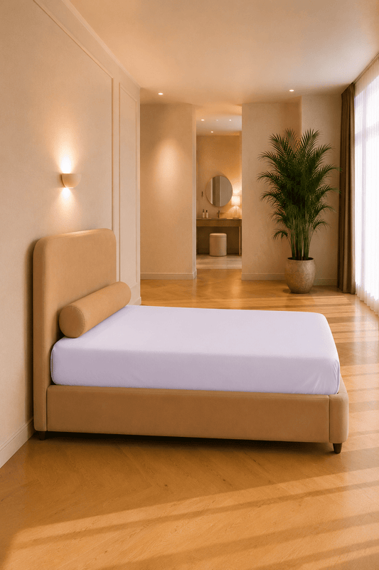 Roze jersey hoeslaken van katoen strak aangebracht rond het matras van een zijbed of extra bed