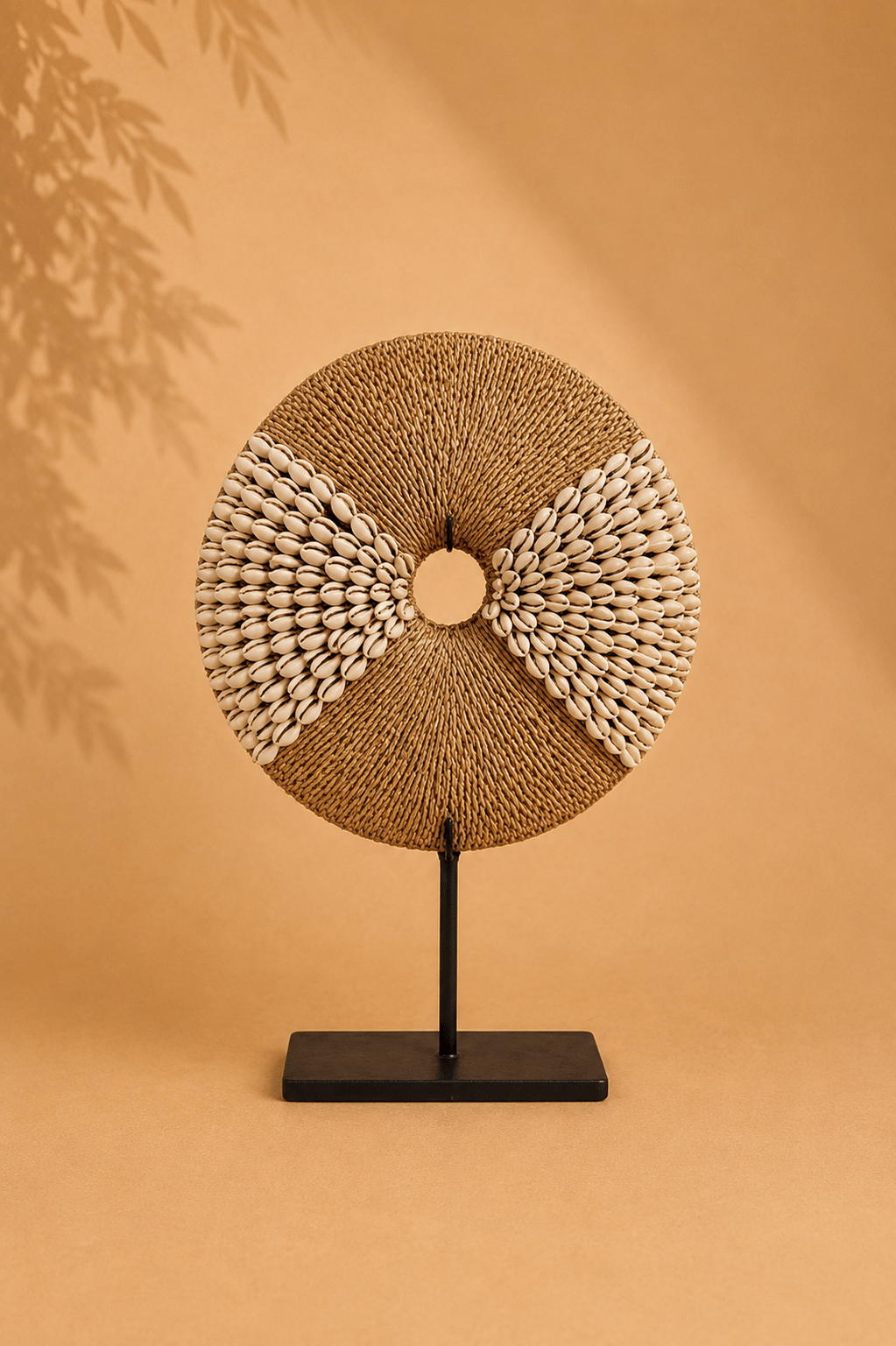 Schelpendecoratie op zwarte standaard naturel op een beige gebladerde achtergrond