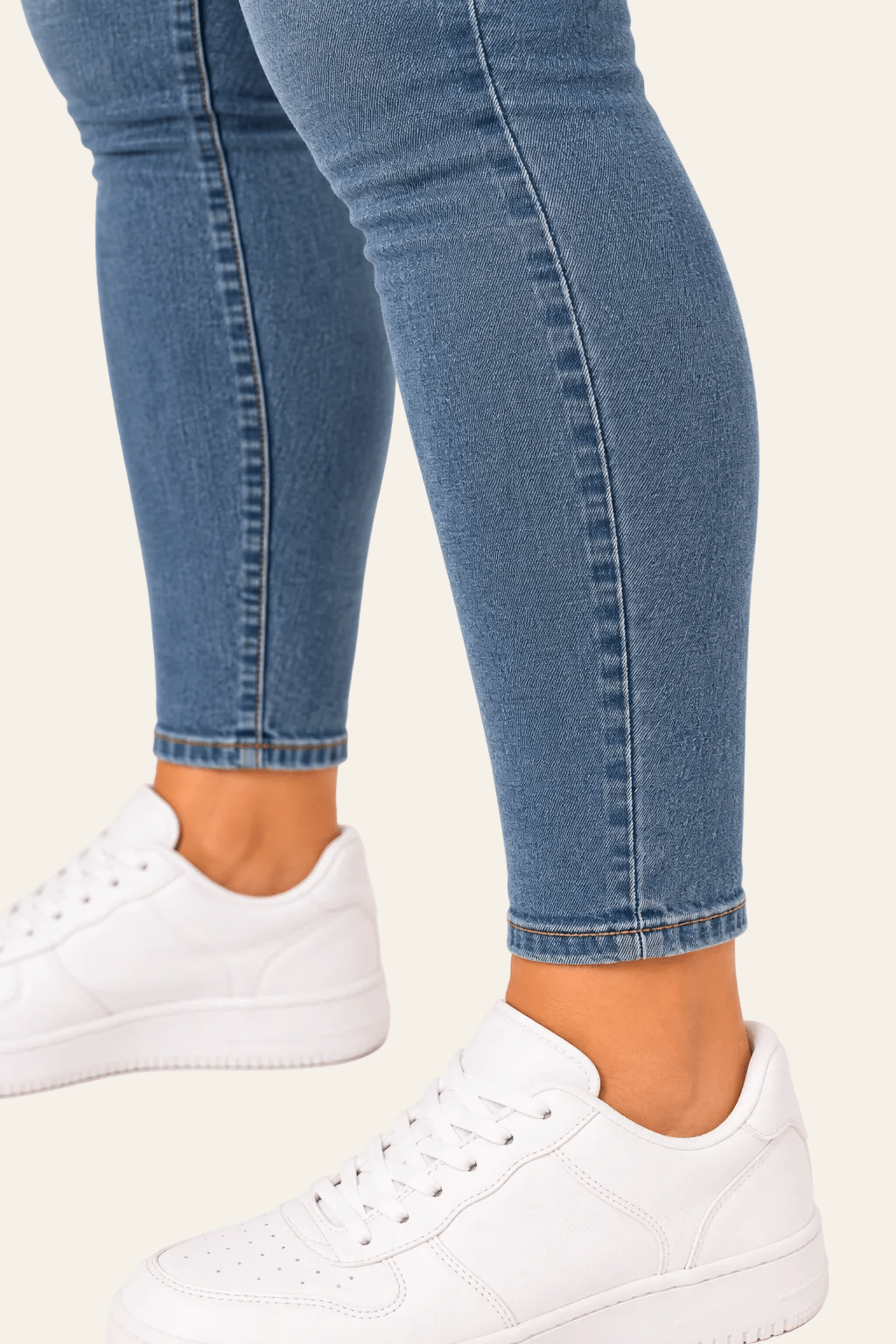 Detail van snit, naad en zoom van skinny damesjeans met smalle pijpen.