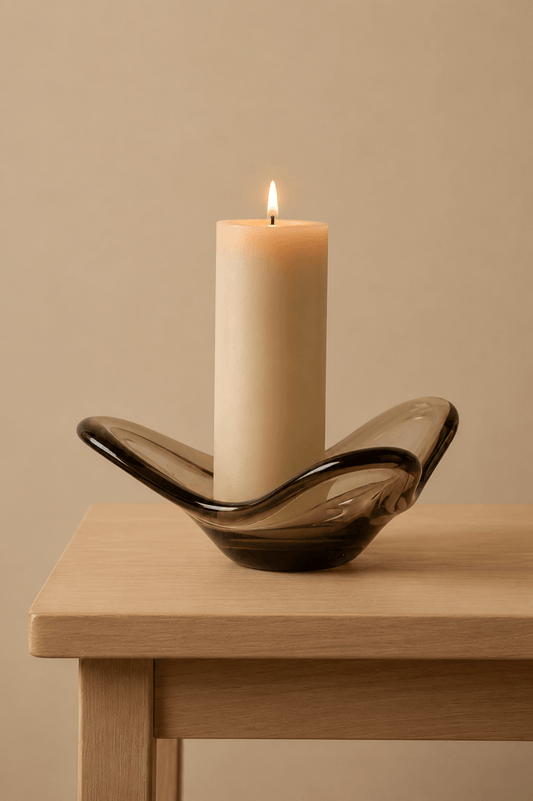 Stijlvolle kandelaar in sculpturale vorm met kaars op een tafeltje in lichtbeige kleur
