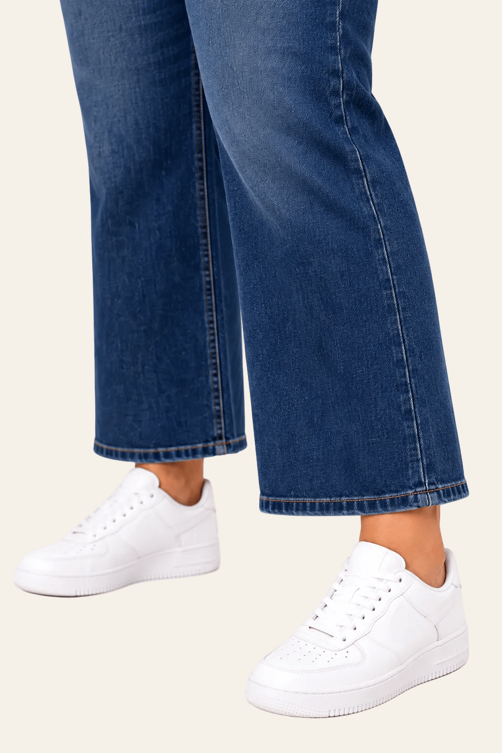 Detail van snit, naad en zoom van stonewash blauwe jeans met wijde pijpen.