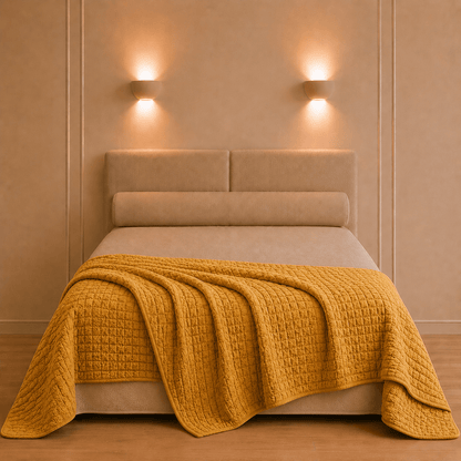 Sfeervol opgemaakt bed met de Swami katoenen bedsprei in goudgele saffraankleur en verfijnde reliëfstructuur