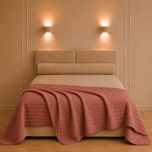Swami bedsprei van Vivaraise in mediterrane aardekleur los gedrapeerd over een opgemaakt bed