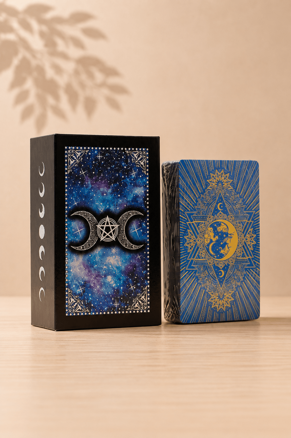 Tarotkaartenset Moon Face met blauwe folie en gids op een beige gebladerde achtergrond