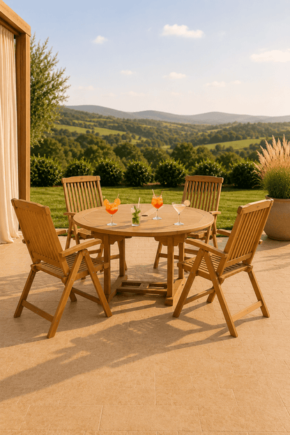 Teakhouten tuinset voor vier personen met ronde tafel vier armstoelen en drankjes op een terras met uitzicht over een groene vallei
