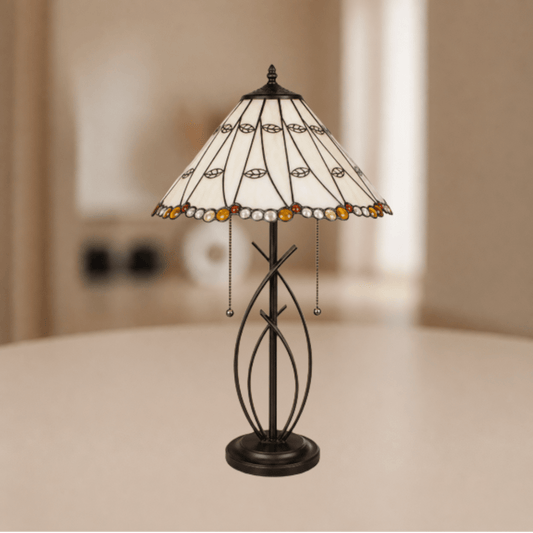 Tiffany tafellamp met brede beigekleurige glas-in-loodkap en sierlijk donker metalen onderstel