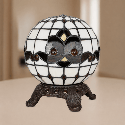 Tiffany uilenlamp met bolvormige glas-in-loodkap, grafisch uilenmotief en metalen vierpootvoet