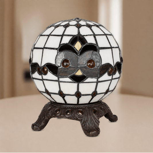 Tiffany uilenlamp met bolvormige glas-in-loodkap, grafisch uilenmotief en metalen vierpootvoet