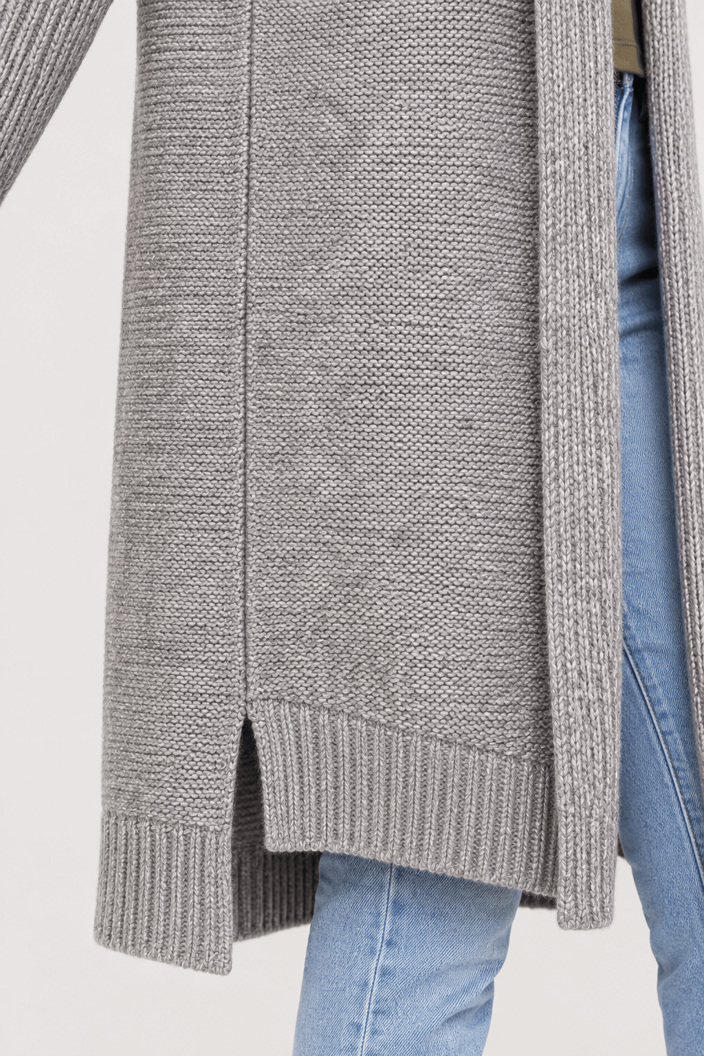 Detail van snit en naadafwerking van vest met capuchon en asymmetrische zoom zonder sluiting.