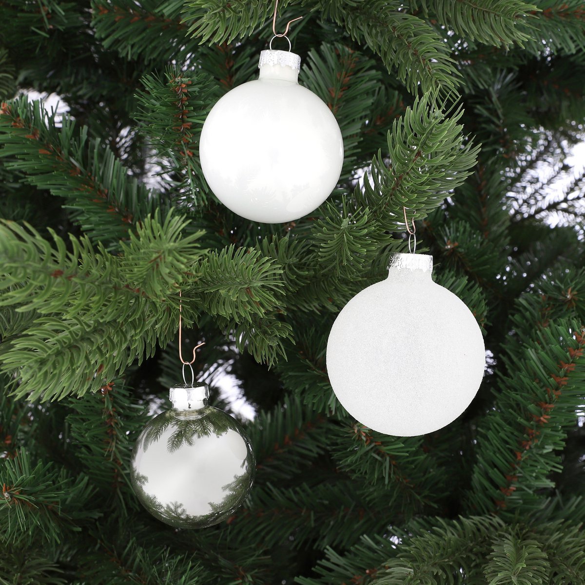 Witte glazen kerstballen in een kerstboom detailfoto