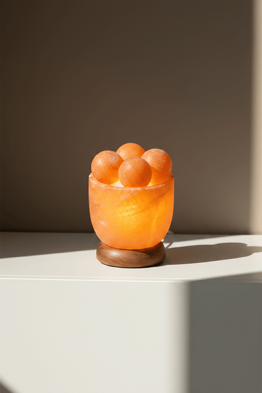 Zoutschaal met 4 aparte massagebollen op een kast met beige achtergrond muur