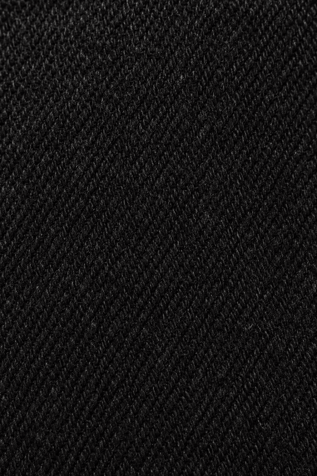 Detail van de zwarte denim stofstructuur van skinny damesjeans.