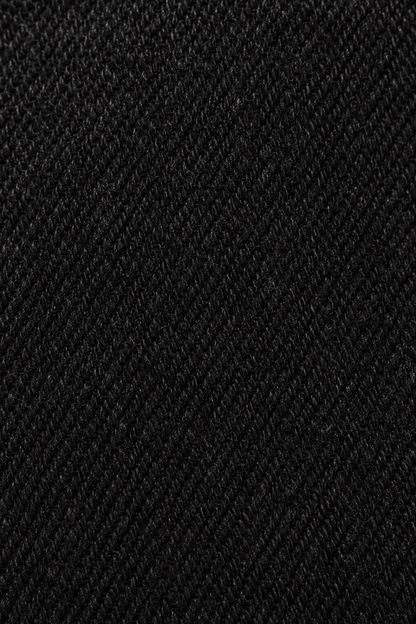 Detail van de zwarte denim stofstructuur van skinny damesjeans.