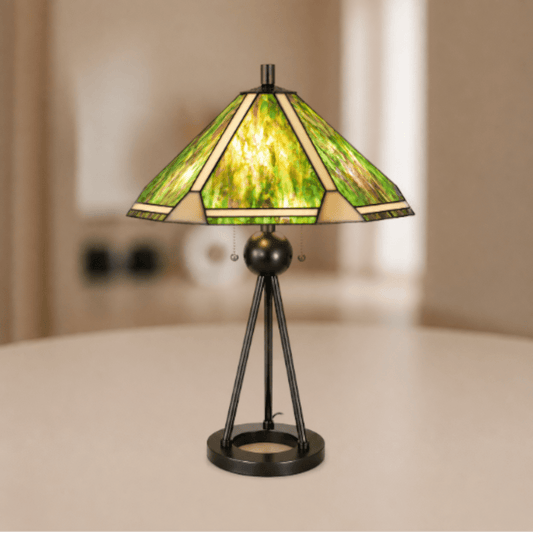 Brandende grote Tiffany tafellamp met groenkleurige glas-in-loodkap en open metalen driepootvoet