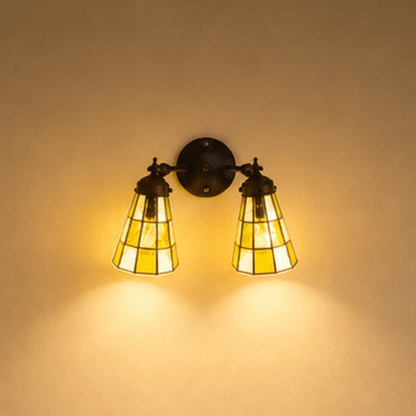 Detail van dubbele Tiffany wandlamp met bruinkleurige glas-in-loodkappen en ronde wandplaat