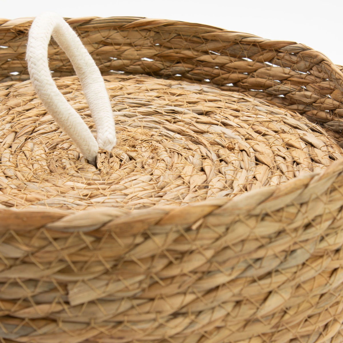 Gewoven mand met bovenaanzicht op deksel afgewerkt met een witte lus in het midden.