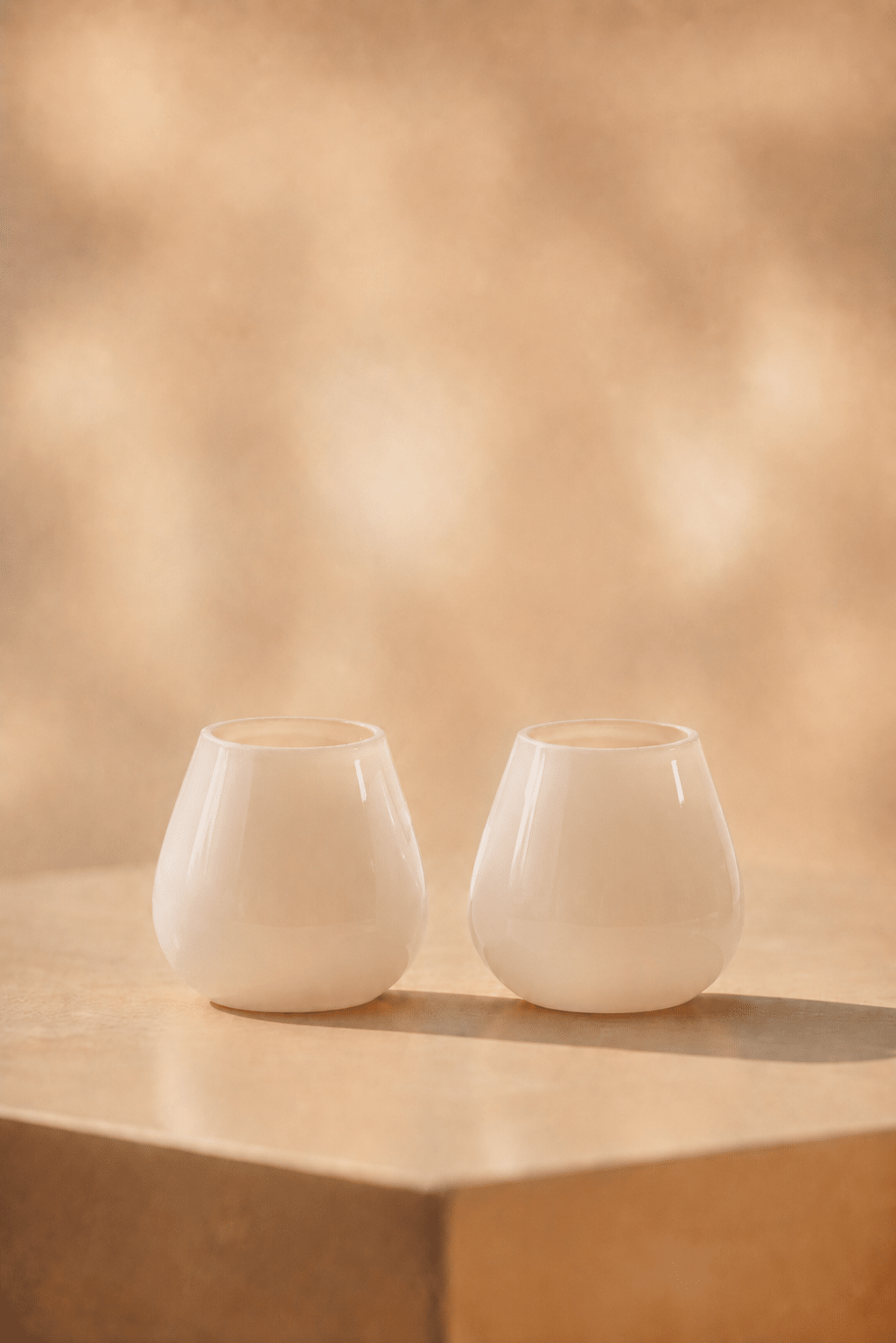waxinelichthoudIvory waxinelichthouder in mat ivory tint op lichtbeige tafel met geblurde achtergrond