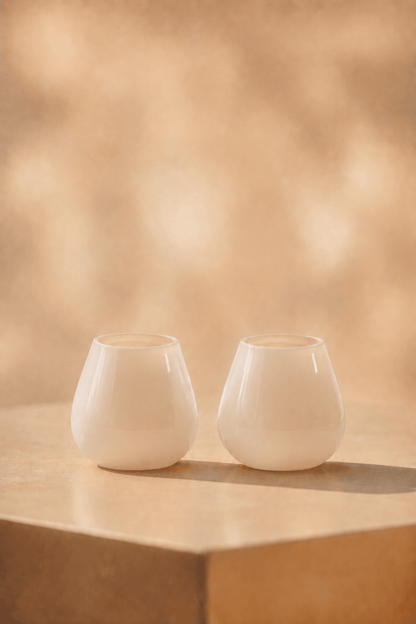 waxinelichthoudIvory waxinelichthouder in mat ivory tint op lichtbeige tafel met geblurde achtergrond