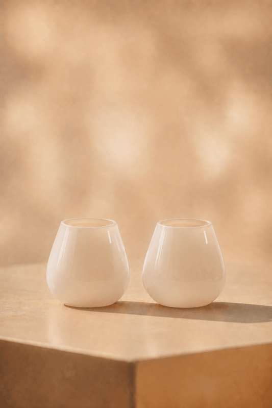 waxinelichthoudIvory waxinelichthouder in mat ivory tint op lichtbeige tafel met geblurde achtergrond